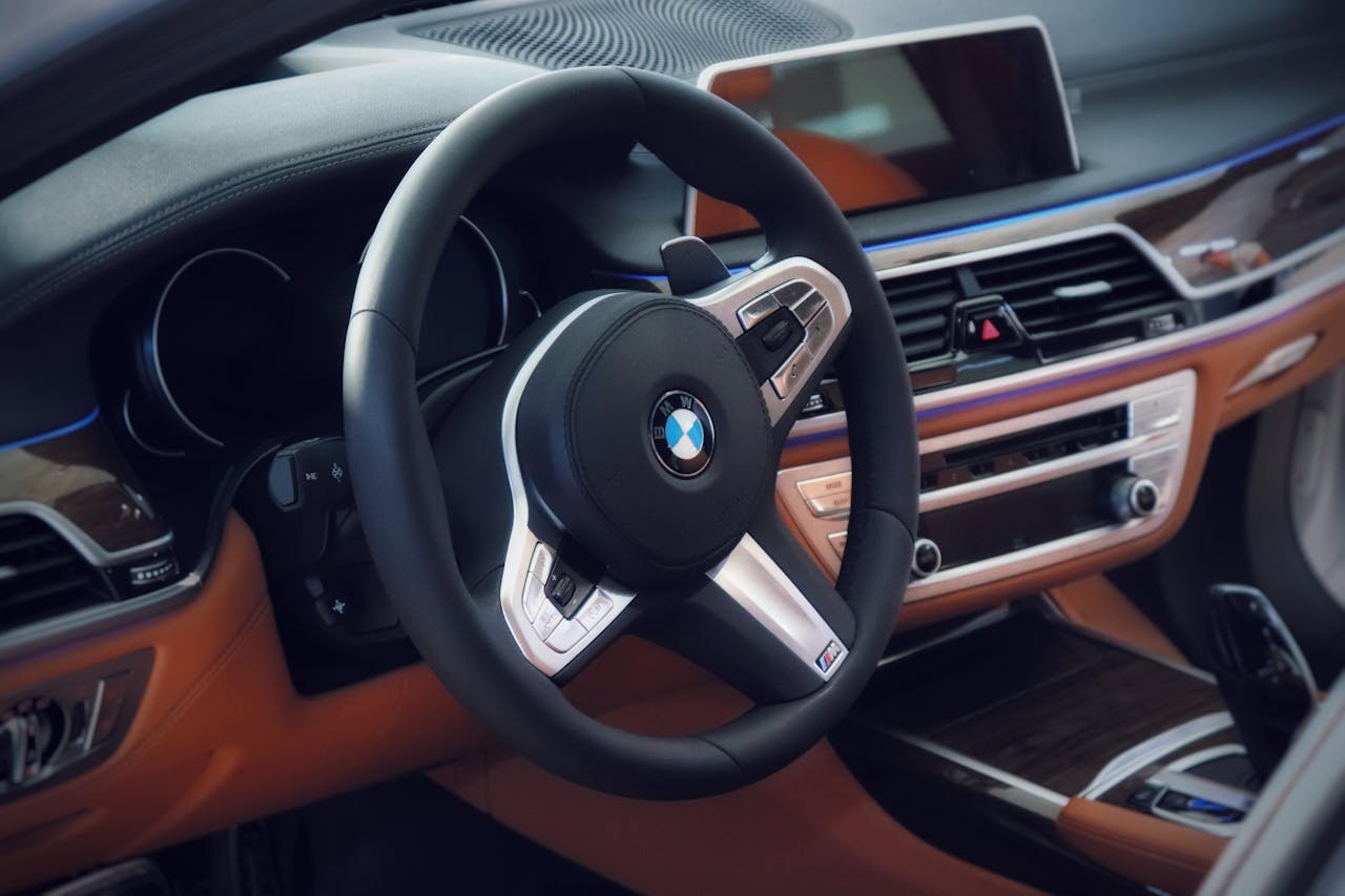 Luxurious BMW car interior featuring a sleek steering wheel and modern dashboard.